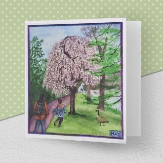 image of the greeting card illustrating the month of May at Kew Gardens, with a tree covered in pale pink blooms in the foreground.