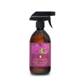 On white image of Invigorating Orchid Care Mist glass bottle with purple wrap featuring illustrated purple flowers.