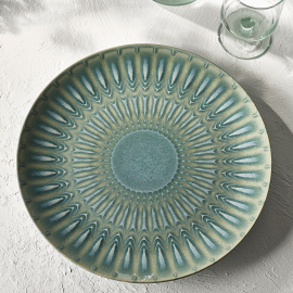 Influenced by the intricate patterns and colours from a diverse range of bugs, the Living Jewel’s serve platter in green and blue colours, marries perfectly the past and present. Modern pattern. Plate on grey table with glass in top right corner.