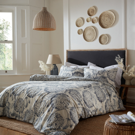 Gorgeous light bed set featuring light navy and dainty sambucus flowers on their stems with a differing print on the reverse side picturing just the flowers.  Bed set displayed on bed.