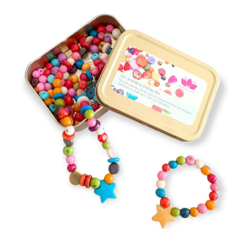 Image of the opened metal box showing its content: colourful beads which are assembled forming a necklace and a bracelet, both featuring a star-shaped bead as a main feature.
