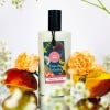 White Jasmine Peach bottle with black cap, white background surrounded by flowers and sliced peach.