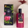 Red Eau de Toilette bottle with deep pink background, surrounded by flowers.