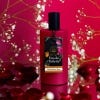 Red Eau de Toilette bottle with deep pink background, surrounded by flowers.