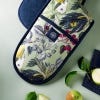 Lifestyle image of Kew Fruit and Floral Double Oven Glove with pale green background and deep blue lining and inner.