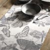 Lifestyle image of beautiful table runner inspired by the stunning and intricate artwork found in the extensive Royal Botanic Gardens, Kew's archives. Light grey tea towel featuring dark grey artwork of insects. Bowls and cutlery pictured.