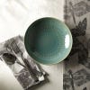 Pasta bowl on complimenting napkins and tea towels from the range. Positioned on white surface next to cutlery.