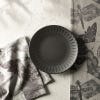 Image of the beautiful stoneware salad plate on a grey table with complimenting tea towels.